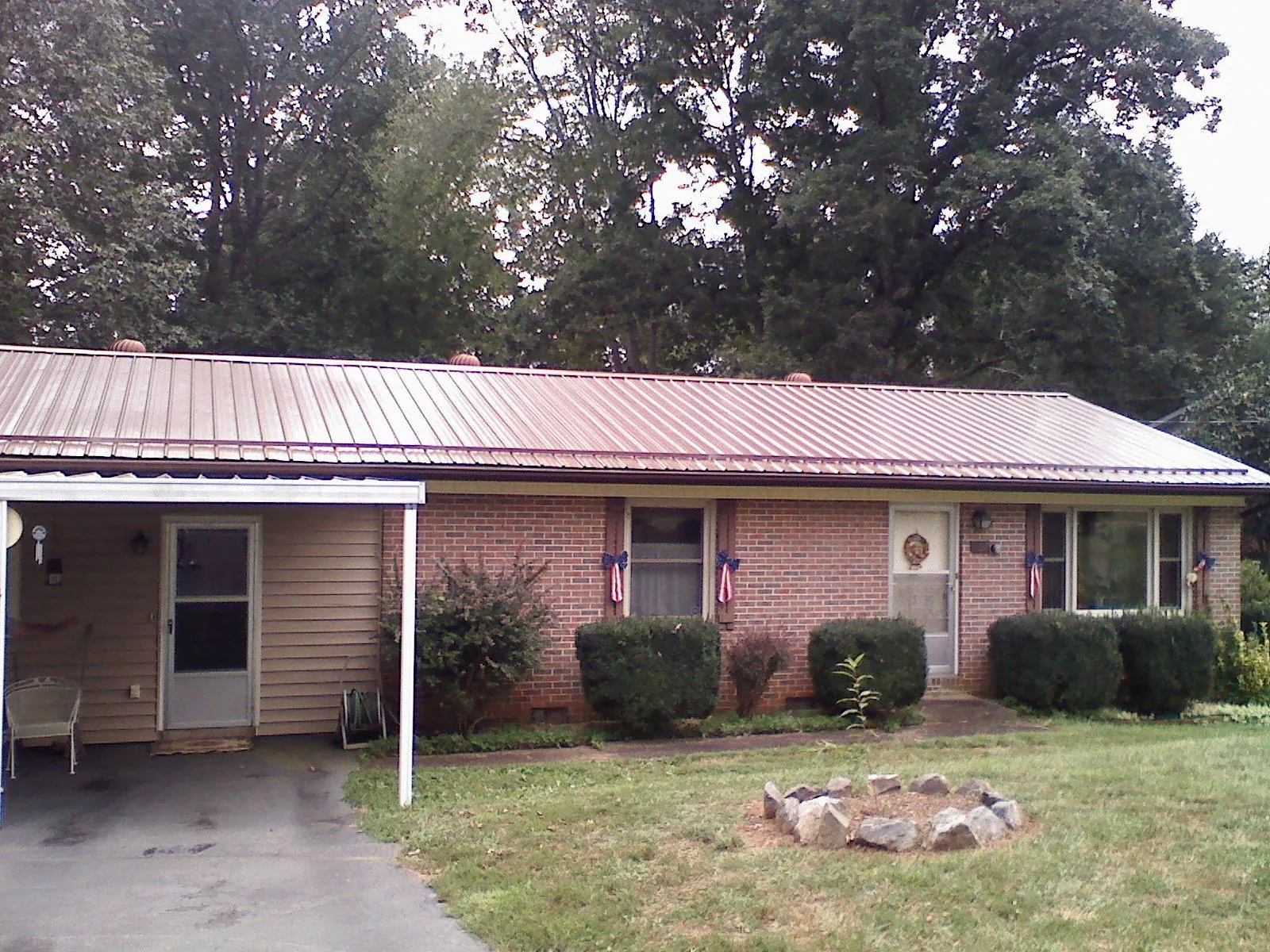 Bronze metal roof and carport on a brick ranch home — Roof Repair work by our crew in Mount Rainier